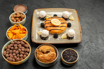 front view delicious little pie with coconut candies on dark-grey background candy biscuit cake pie cookie sweet
