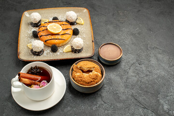 front view delicious little pie with cup of tea on dark background candy biscuit cake pie cookie sweet