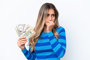 Young Uruguayan woman taking a lot of money isolated on white background having doubts