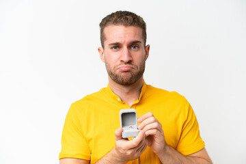 Young man holding a engagement ring isolated on white background