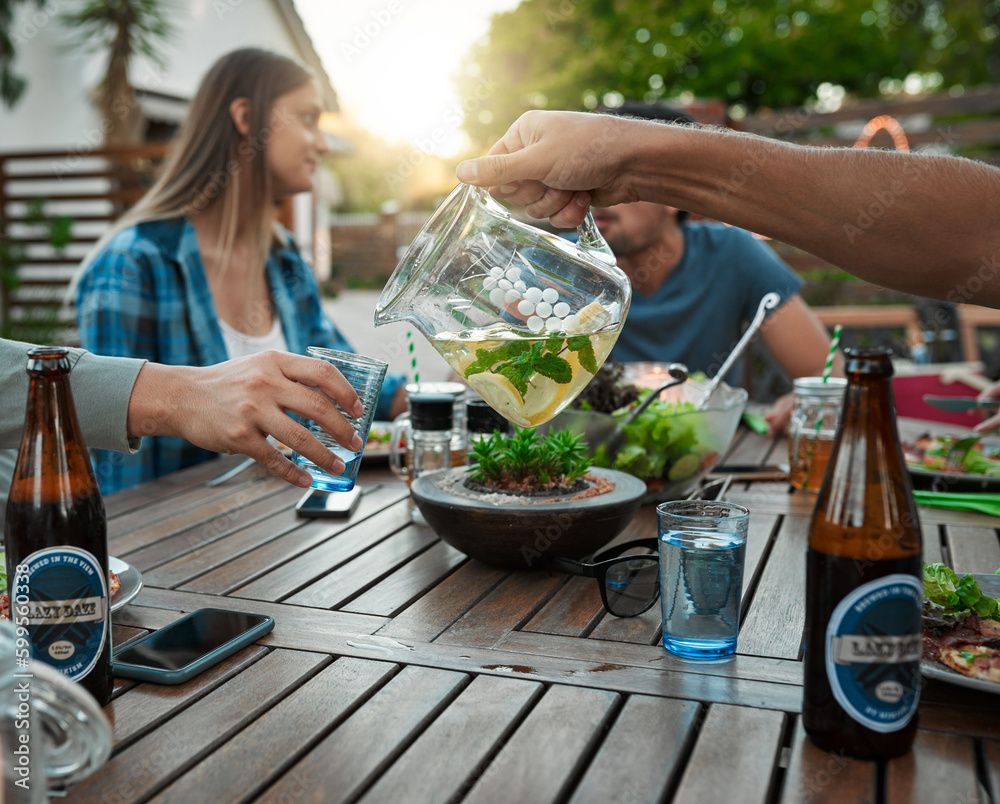 Poster some refreshing water. two unrecognizable friends pouring water in a glass for each other outside ar