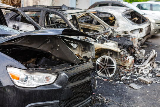 A cropped front view of a burned and abandoned rusty cars