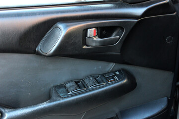 Obraz na płótnie Canvas Window control buttons in old car. Old Car window control panel. Door handle with power window control. Vintage japanese car, Close up old car interior. 