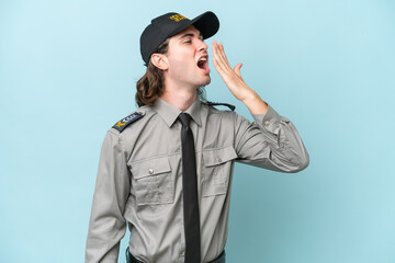 Young safeguard man isolated on blue background yawning and covering wide open mouth with hand