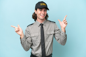 Young safeguard man isolated on blue background pointing finger to the laterals and happy