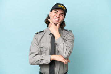 Young safeguard man isolated on blue background smiling
