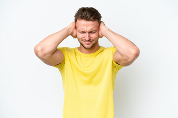 Young blonde caucasian man isolated on white background frustrated and covering ears