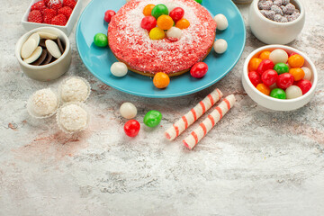 front view delicious pink cake with colorful candies on white desk dessert goodie rainbow color cake candy