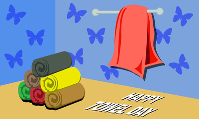 towels rolled up neatly stacked on the table and red towels hanging on the wall with a butterfly pattern with bold text commemorating TOWEL DAY