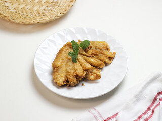 Banana fritters in white ceramic plate. In Indonesia it called pisang goreng kipas. selective focus