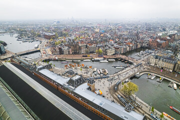 Obraz premium Canal cruise boat in front of Amsterdam central railway station in Amsterdam, Netherlands. drone shot. High quality photo