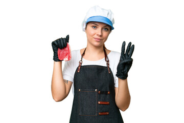 Butcher woman wearing an apron and serving fresh cut meat over isolated chroma key background happy and counting three with fingers