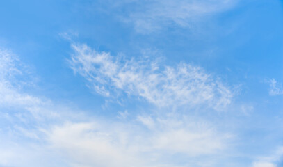 Blue sky and white clouds background - Pillowy clouds cover a blue sky in the background