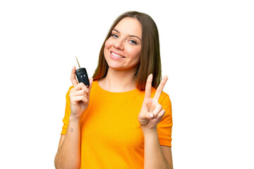 Young woman holding car keys over isolated chroma key background smiling and showing victory sign