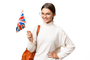 Teenager student caucasian girl holding an United Kingdom flag over isolated background posing with arms at hip and smiling