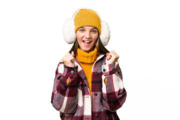 Teenager caucasian girl wearing winter muffs over isolated background celebrating a victory in winner position