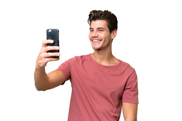 Young handsome caucasian man over isolated background making a selfie