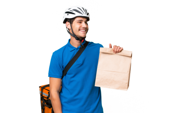 Young caucasian man taking a bag of takeaway food over isolated background looking side