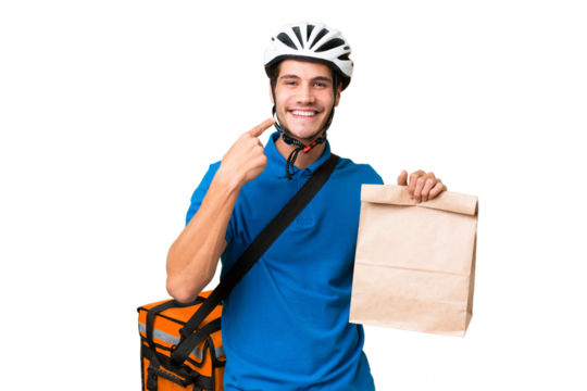 Young caucasian man taking a bag of takeaway food over isolated background giving a thumbs up gesture
