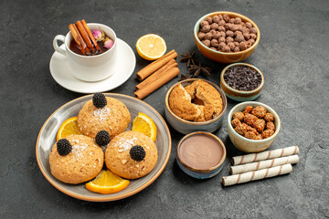 front view yummy cookies with cup of tea on a dark grey background cake pie dessert biscuit tea cookie