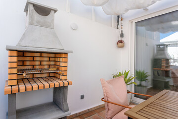 Modern eco-friendly barbecue on the terrace of the apartment with a table.