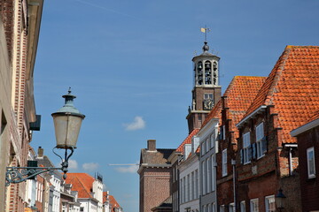 Historical houses facades and the clock tower of the Stadhuis (Town Hall) located in Botermarkt...