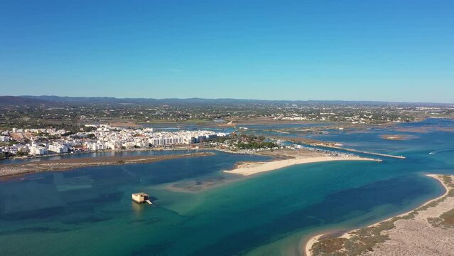 Aerial view. Drone flight over the natural Portuguese park Ria formosa over the village of Fuseta. Rescue house in the middle of a bay with turquoise water