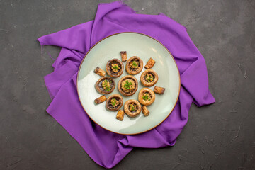 top view cooked mushrooms inside plate on a purple tissue dish meal cooking mushrooms dinner