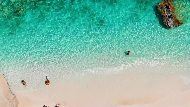 Cala Goloritze Sardinia Beach Sardinia Italy, a beautiful beach full of beach umbrellas and people sunbathing and swimming in the turquoise water Sardinia, Italy Golfo Di Orosei during summer