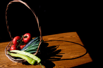 Organic vegetables in a wooden basket with a silhouette on a wooden table...