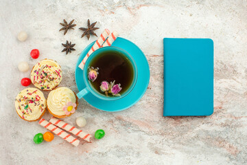 Fototapeta na wymiar top view cup of tea with candies and cakes on a white background tea dessert biscuit cake pie