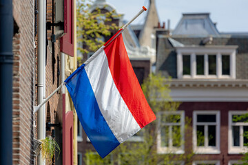 04 May every year, Remembrance of the Dead (Nationale Dodenherdenking) National flag of the Netherlands with half-mast, Memorial to victims of the world war two, Dutch flag hanging outside building.