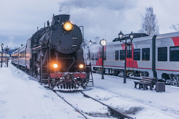 Retro steam train arrives at winter morning.