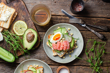 toasts with cream cheese, salmon, egg, avocado, cucumber  in a plate