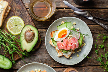 toasts with cream cheese, salmon, egg, avocado, cucumber  in a plate