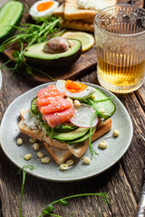 toasts with cream cheese, salmon, egg, avocado, cucumber  in a plate
