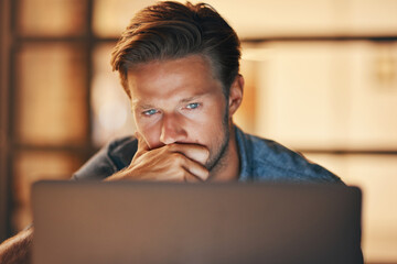 Pulling an all-nighter to complete a project. a handsome young man looking thoughtful while working...