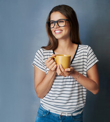 Your level of confidence defines the pace towards your goals. Studio shot of an attractive young woman holding a coffee mug against a gray background.