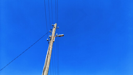 Power line pole on a blue sky background