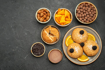 top view delicious cookies with nuts and orange slices on dark-grey background cookies biscuit tea sweet cake