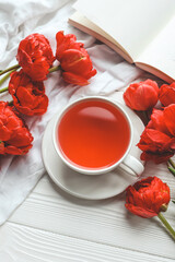 Beautiful spring composition, good morning concept. Cup of tea, peonies, open book