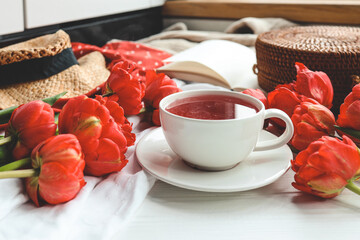 Beautiful spring composition, good morning concept. Cup of tea, peonies, open book