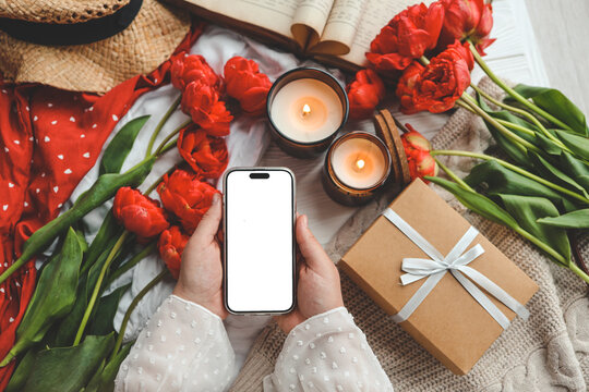 Mobile phone and spring flower tulips on a festive background. Theme of love, mother's day, women's day flat lay