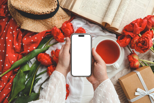 Mobile phone and spring flower tulips on a festive background. Theme of love, mother's day, women's day flat lay