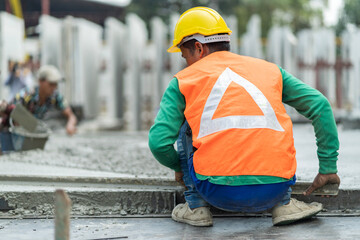 Male worker in a precast wall factory (Precast) is forming a wall with cement. and smooth the plaster in the prepared mold