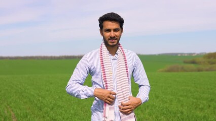 Young indian farmer working in a wheat field