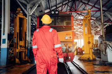 Engineer railway wearing safety uniform and helmet under checking under train ,wheels and control system for safety travel passenger. Maintenance cycle concept.