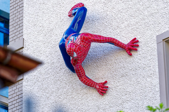 Red and blue Spider-Man sculpture climbing at house facade at City of Zürich on a sunny spring day. Photo taken May 3rd, 2023, Zurich, Swtzerland. 