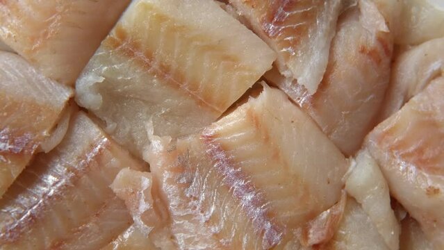 Raw fish fillet is spinning. Top view. Slices of fresh whitefish. Full frame. Sashimi rotation. Close up. Marine market. Video for sale. Cod, pollock loin steaks. Pangasius, tilapia pieces background.
