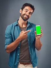 I know a good app when I see one. Studio shot of a handsome young man showing a mobile phone with a...
